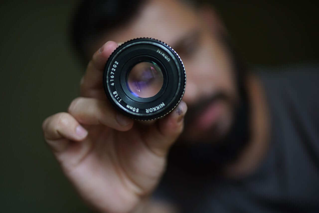 Man holding focused lens